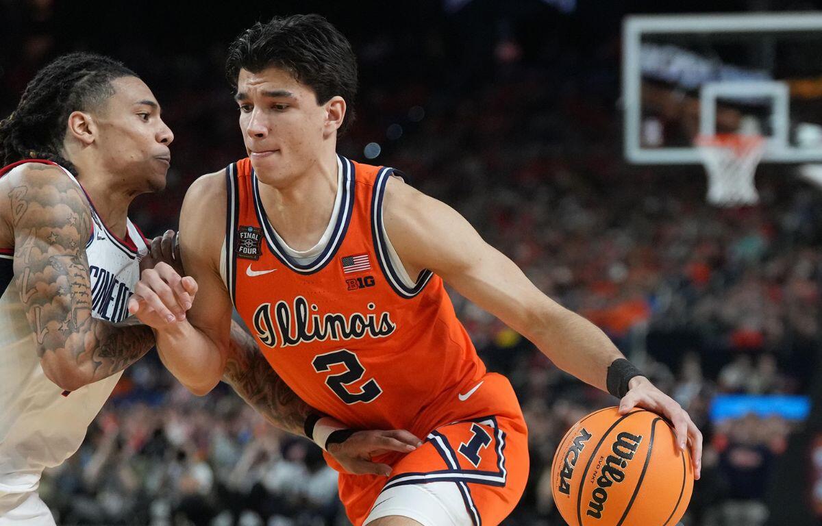 Illinois guard (No. 2) dribbles the ball as a defender guards closely during a college basketball game.