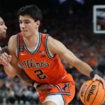 Illinois guard (No. 2) dribbles the ball as a defender guards closely during a college basketball game.