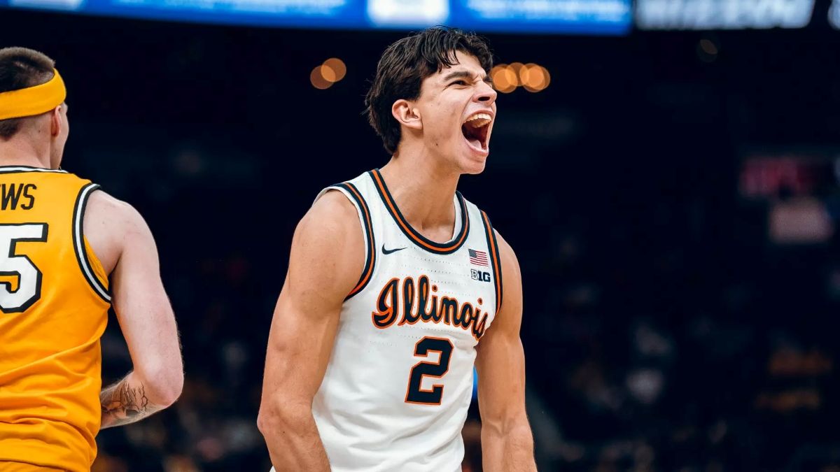 Illinois player wearing number 2 on white jersey yells with mouth open on the basketball court, opponent in yellow number 5 nearby.