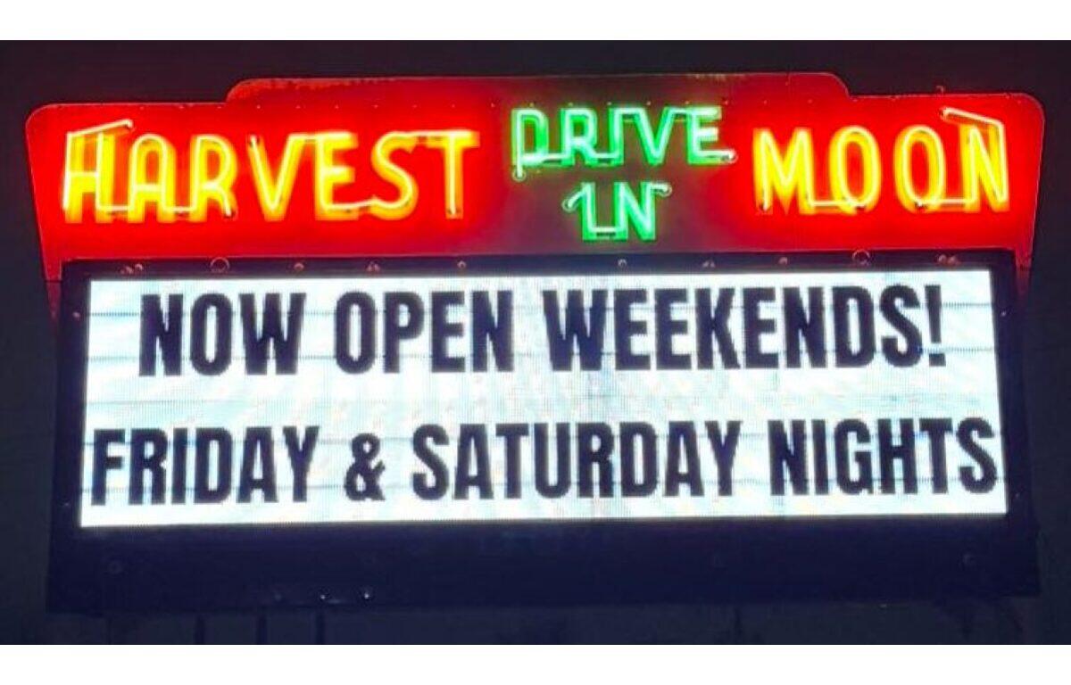 Neon sign for Harvest Moon Drive-In with a marquee reading 'Now Open Weekends! Friday & Saturday Nights'.