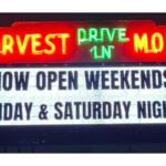 Neon sign for Harvest Moon Drive-In with a marquee reading 'Now Open Weekends! Friday & Saturday Nights'.
