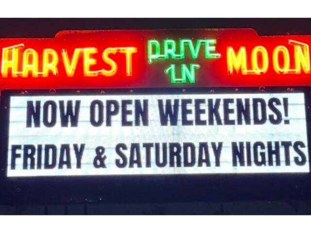 Neon sign for Harvest Moon Drive-In with a marquee reading 'Now Open Weekends! Friday & Saturday Nights'.