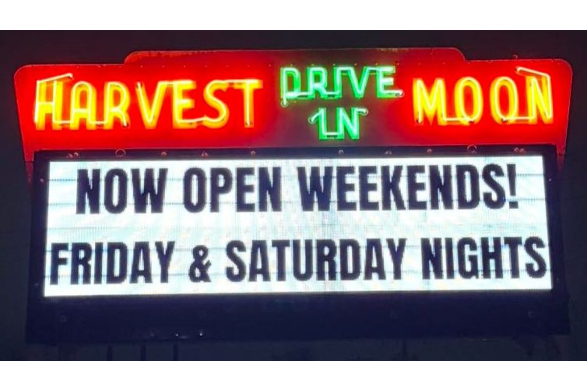 Neon sign for Harvest Moon Drive-In with a marquee reading 'Now Open Weekends! Friday & Saturday Nights'.