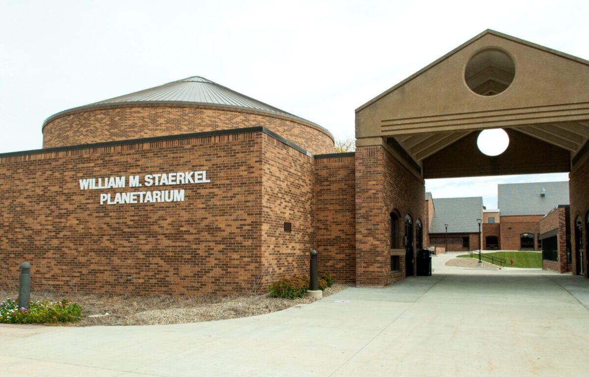 Brick William M. Staerkel Planetarium building with a circular skylight dome and archway entrance.