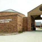 Brick William M. Staerkel Planetarium building with a circular skylight dome and archway entrance.