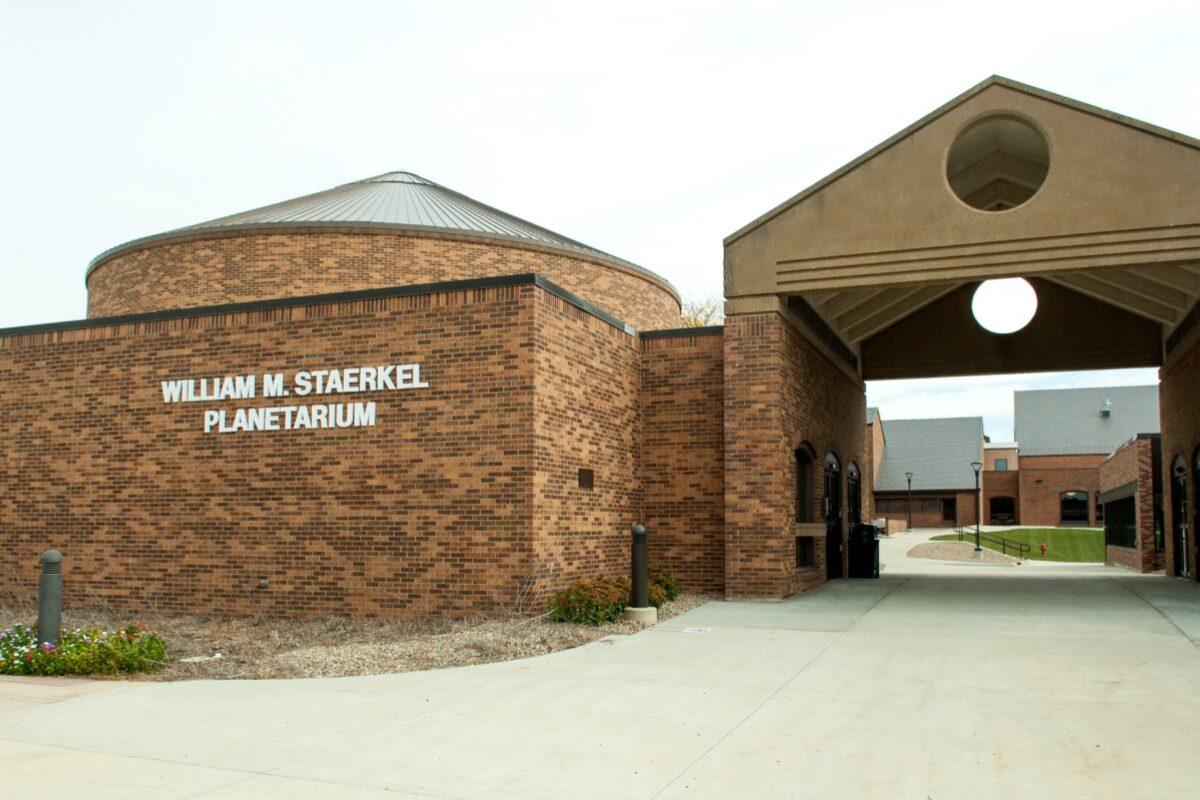 Brick William M. Staerkel Planetarium building with a circular skylight dome and archway entrance.