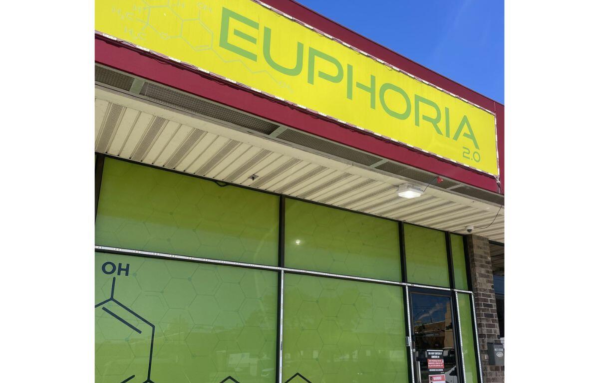 Exterior storefront with a bright yellow sign reading 'EUPHORIA 2.0' above lime-green glass windows and a doorway to the right.