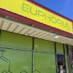 Exterior storefront with a bright yellow sign reading 'EUPHORIA 2.0' above lime-green glass windows and a doorway to the right.