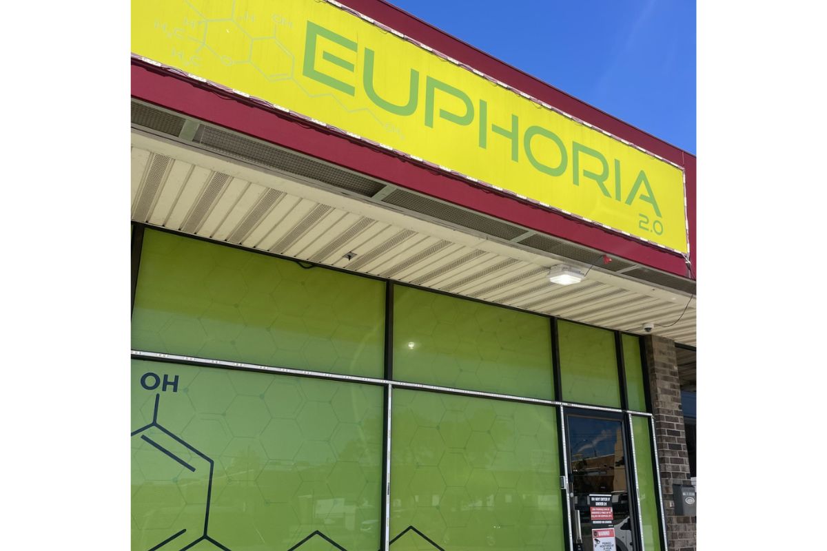 Exterior storefront with a bright yellow sign reading 'EUPHORIA 2.0' above lime-green glass windows and a doorway to the right.