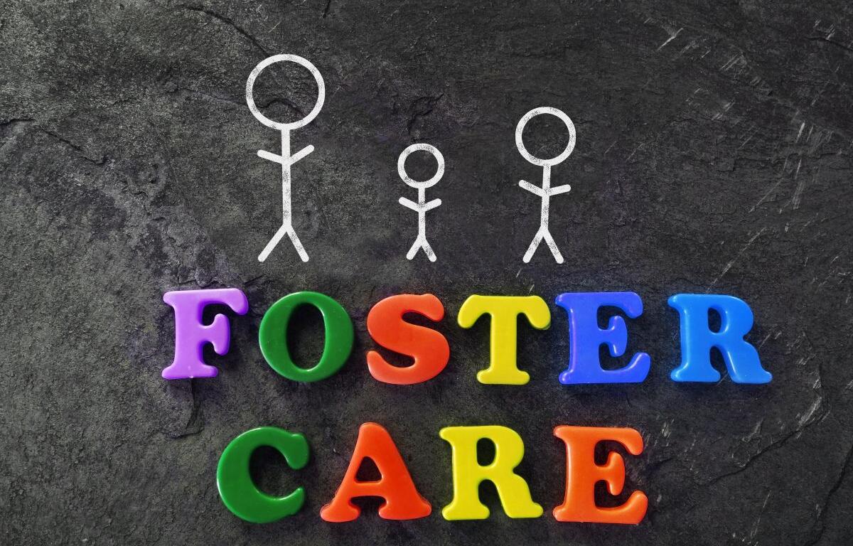 White stick-figure family above colorful letters spelling FOSTER CARE on a dark textured background.