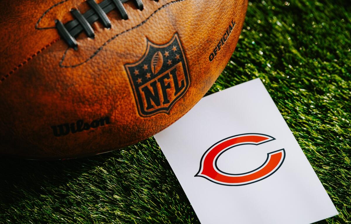Orange NFL football on grass beside a white card with the Chicago Bears logo
