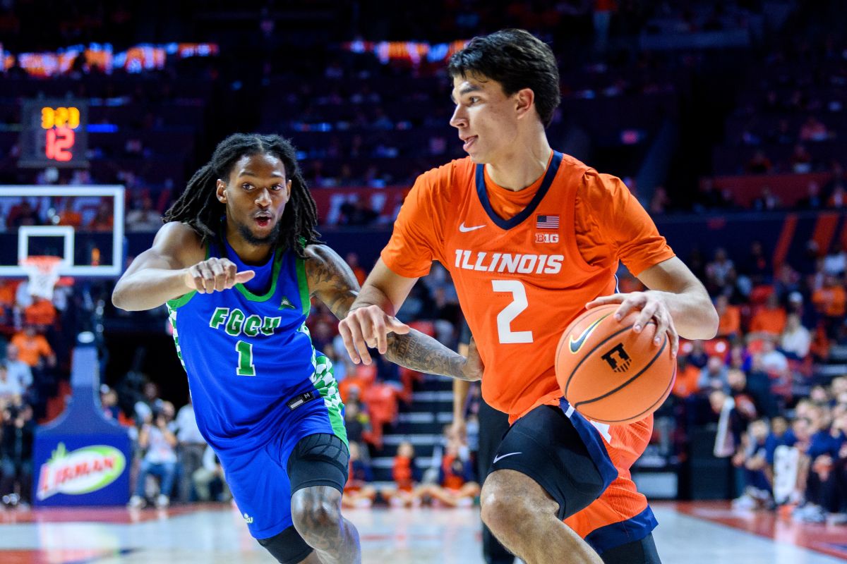 Illinois player in orange #2 dribbles with the ball as FGCU defender in blue #1 pursues.