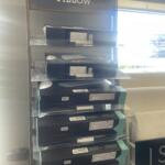 Display of Tempur-Pedic pillows on a metal rack with a sign that reads 'FIND YOUR PERFECT PILLOW' at the top.