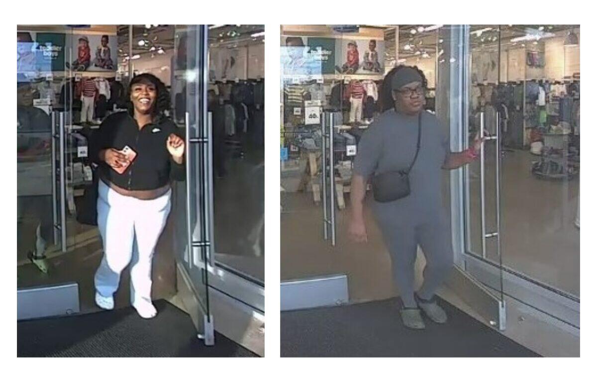 Two women exit a clothing store through glass doors; left woman smiles, wearing a black top and white pants, holding a card. Right woman in gray outfit with a black crossbody bag exits beside her.