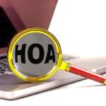 Magnifying glass with the word HOAX on a laptop keyboard, symbolizing debunking misinformation online.